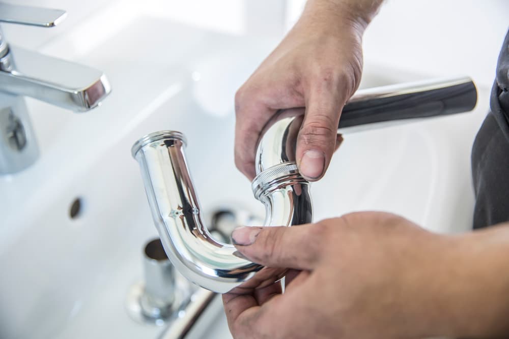 Installateur arbeitet am Waschbecken.